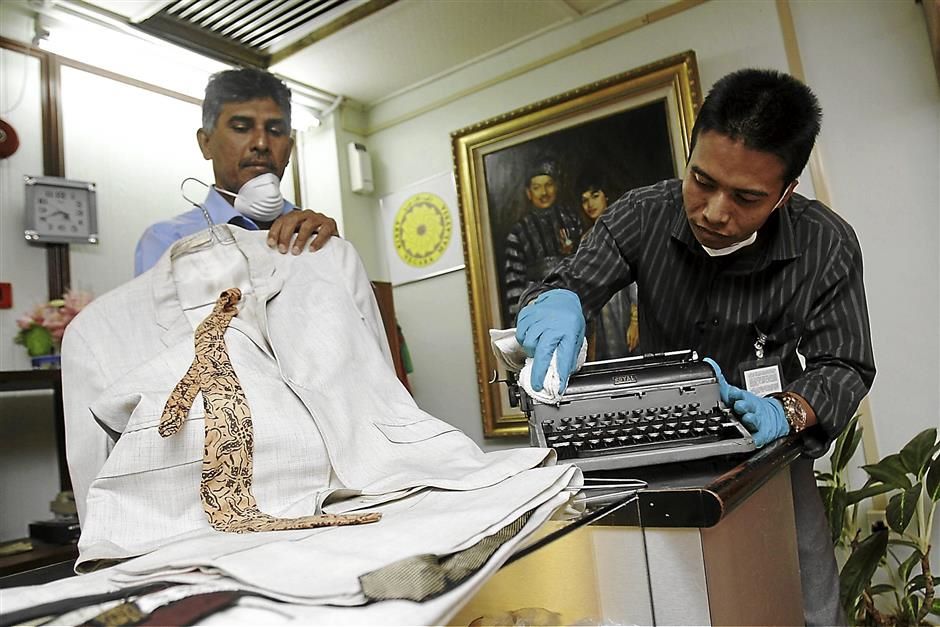 (BRIEF CPTION) Rumah P.Ramlee Asst.Manager,Mohd Shaiful Izham Muhammad Faudzi,31 (right) cleaning the typewriter wich is used by P.Ramle to type lyrics of the song after arrange and Mohamed Mathivanan Suhaibudeen,49 checking on an apparel used by P.Ramlee when acting in 1953.All personal items belonging to P. Ramlee will be on display at level3 in Komtar inconjunction with  P. Ramlee festival organise by Penang Institute at level 3 in Komtar this 7 January 2013.